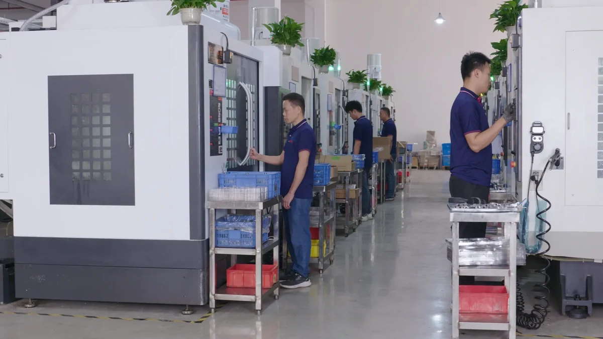 Operators at CNC machines with work carts and parts containers