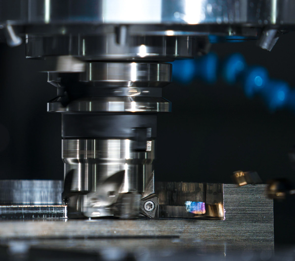 Face milling a clamped metal workpiece with an insert cutter