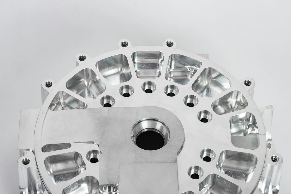Machined circular metal component with pockets and mounting holes