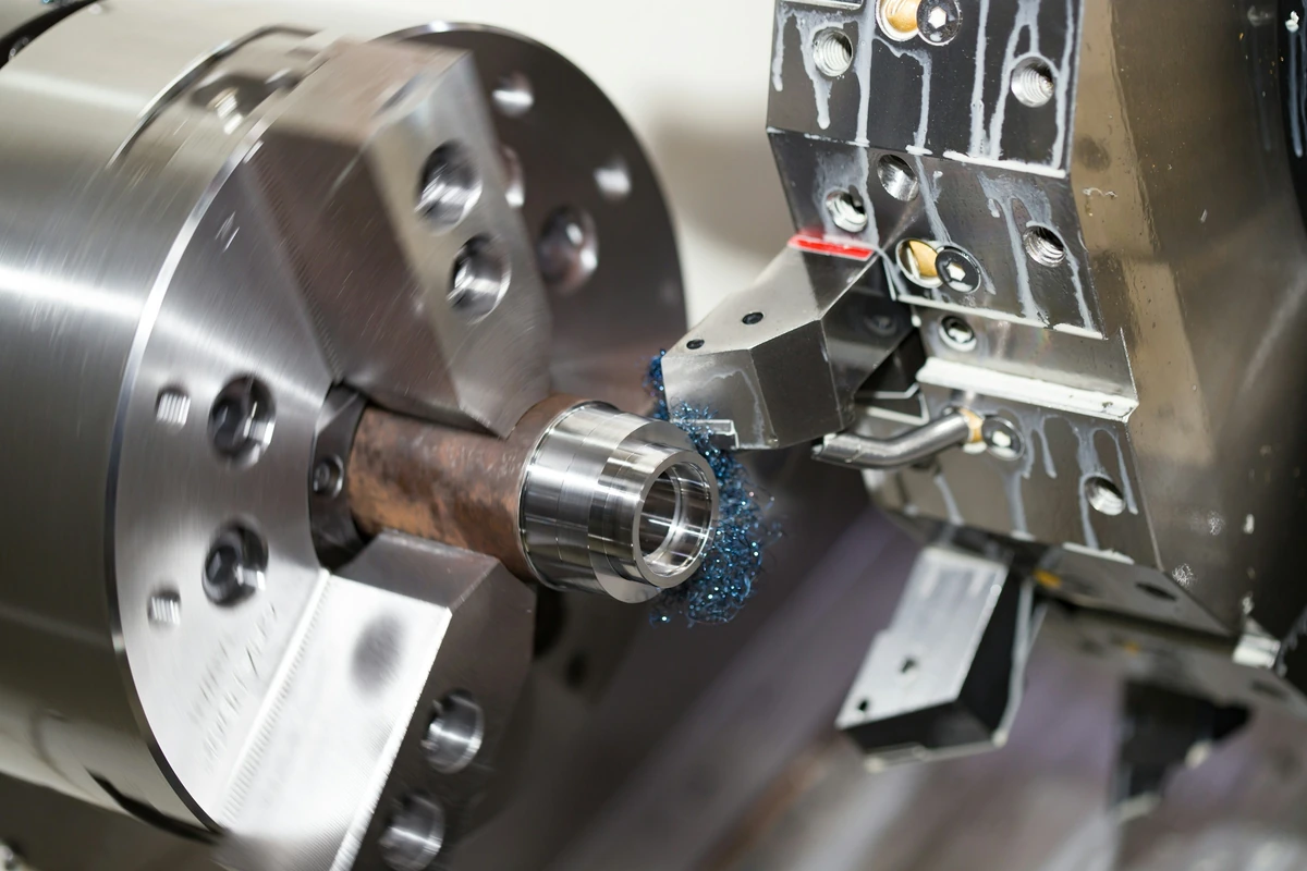 CNC lathe chuck and cutting tool holding a metal workpiece