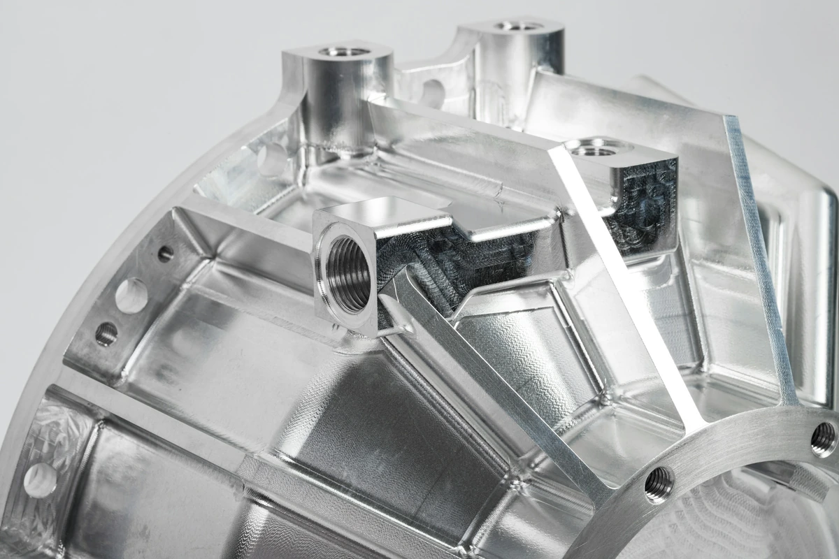 Machined aluminum housing with ribs and threaded ports
