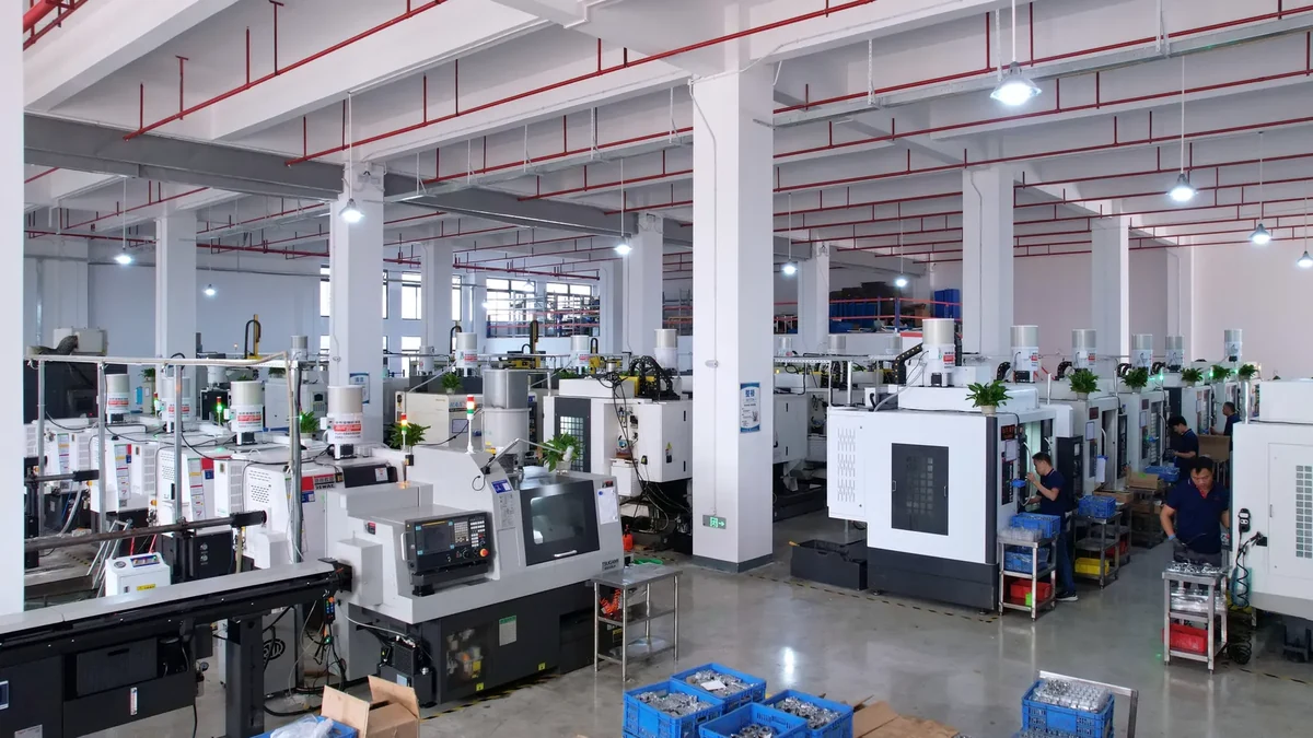 CNC workshop with enclosed machines, marked aisles and parts containers