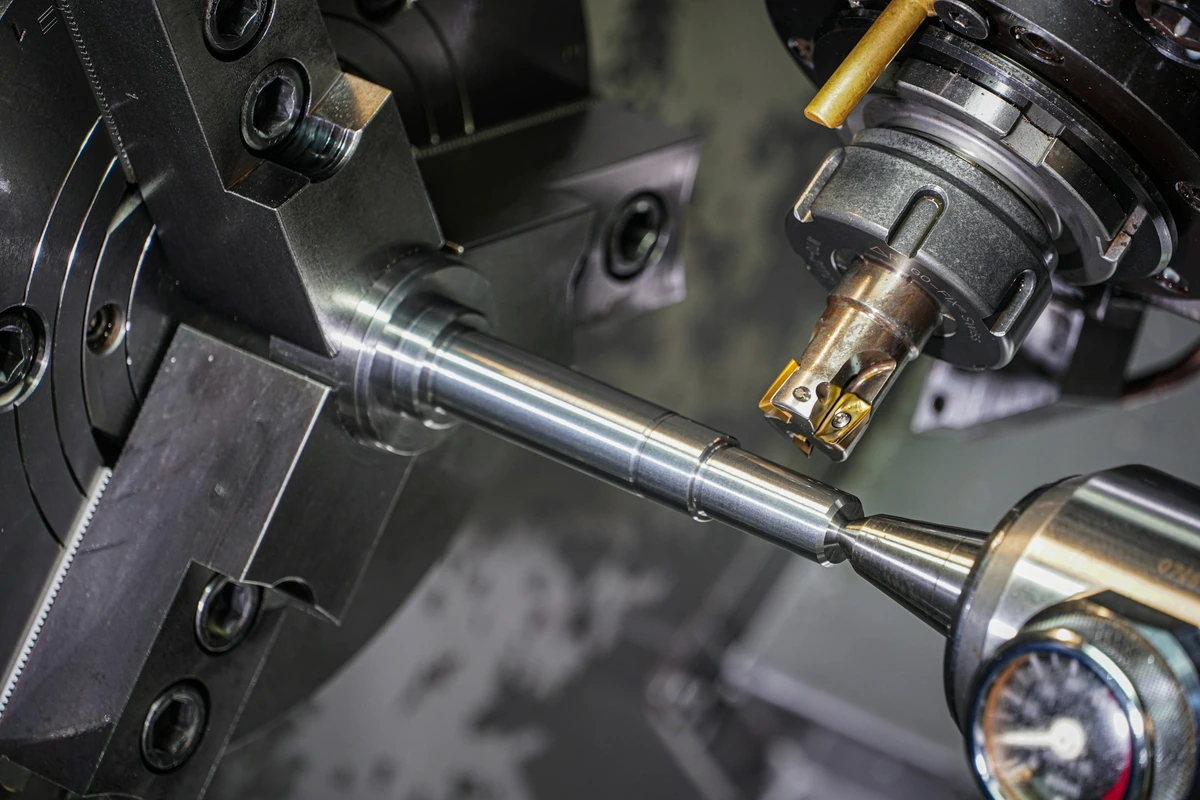 Turning a shaft held between machine fixtures